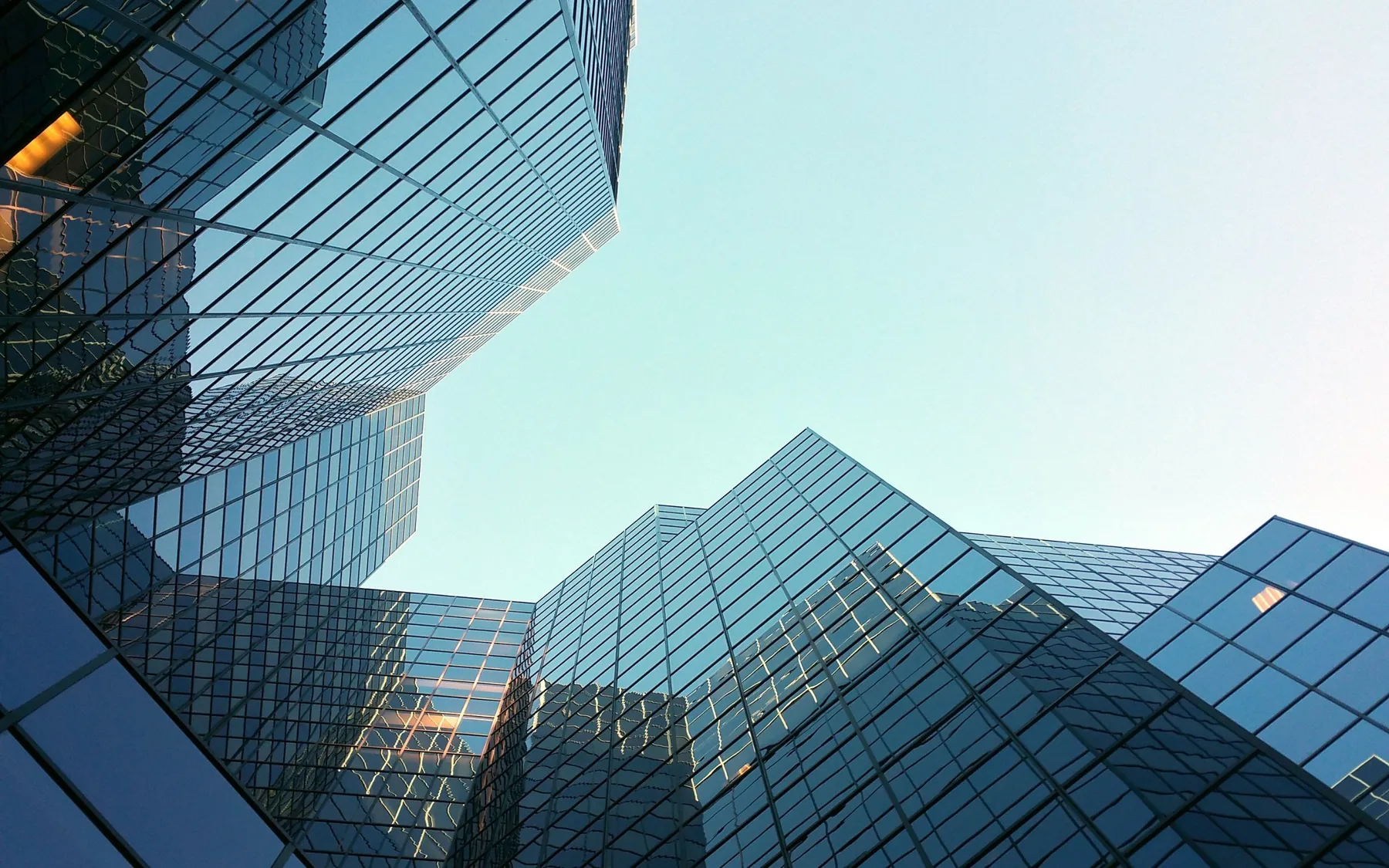Glass office towers photographed looking up from street level