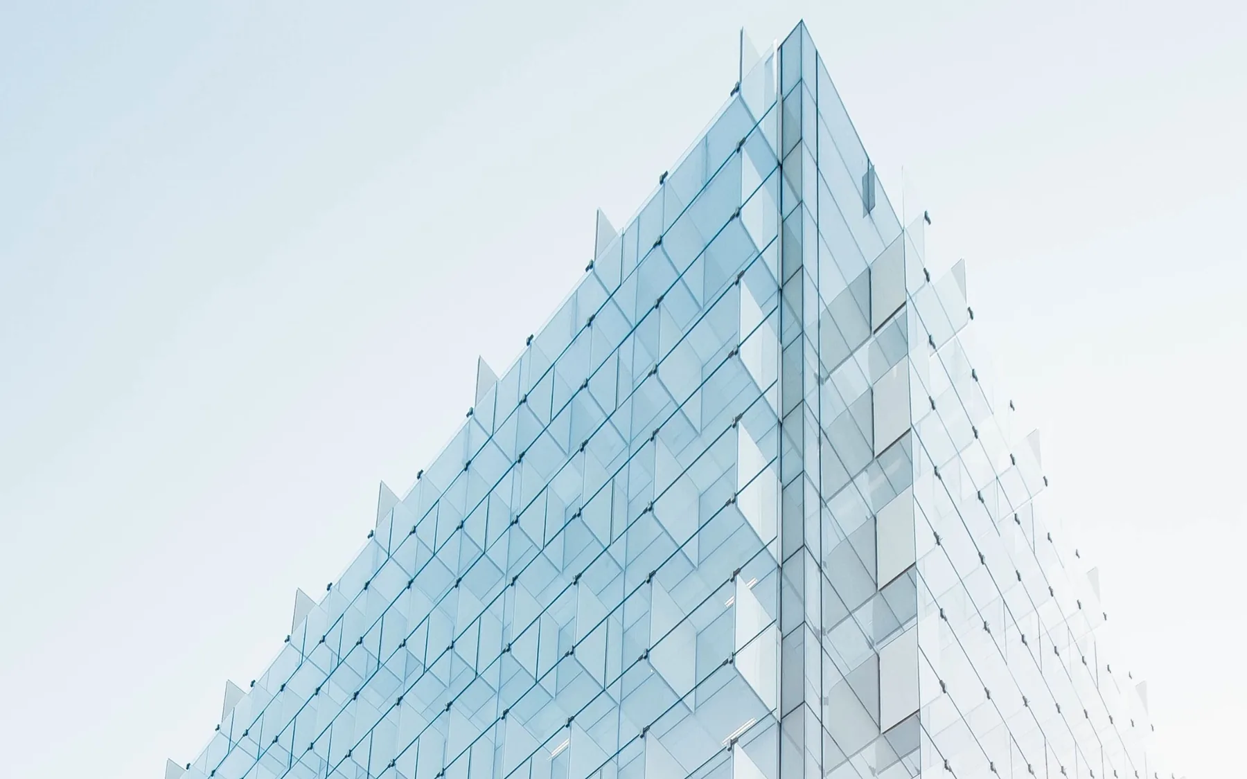 Pale glazed building facade against a clear sky
