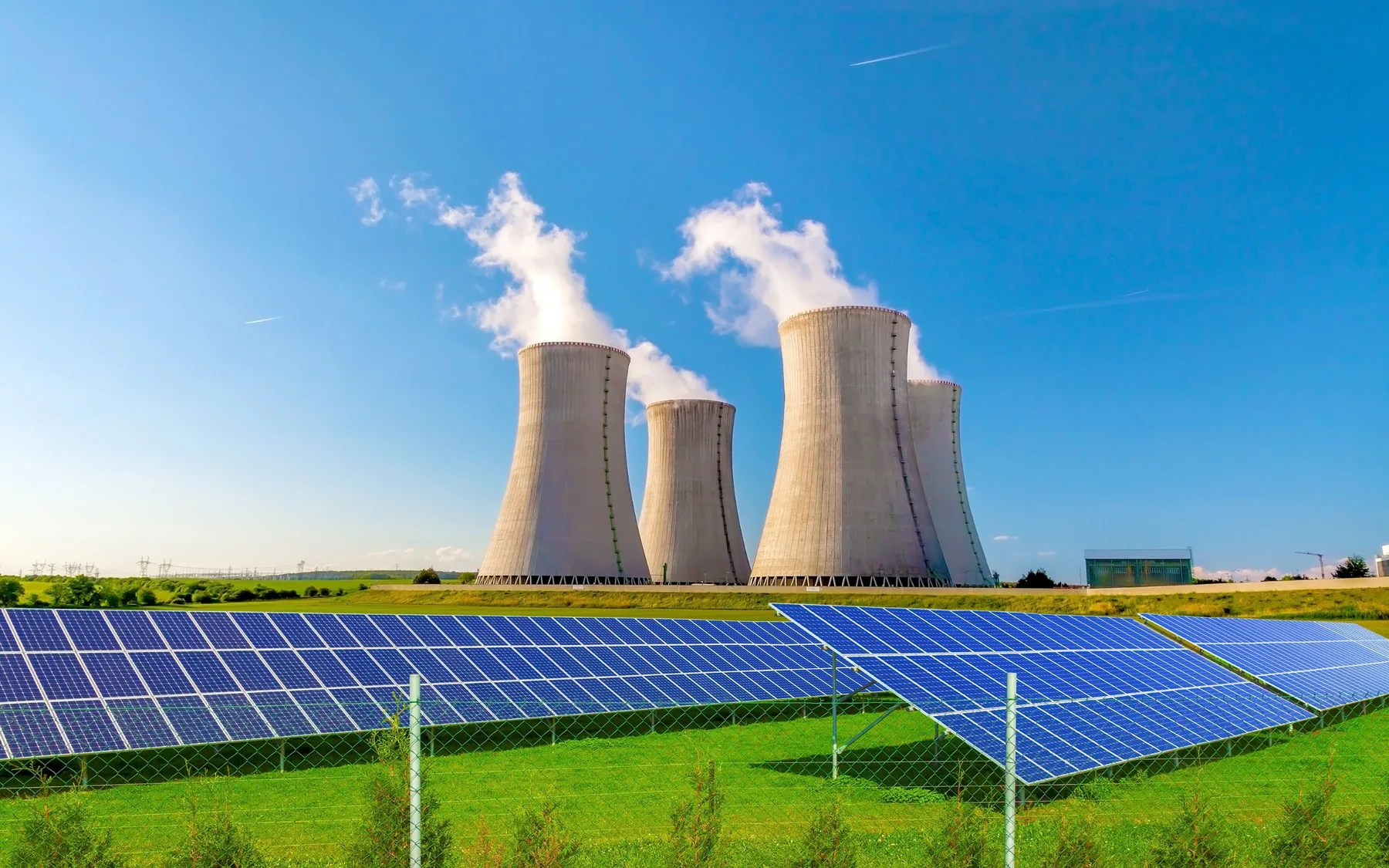 Ground-mounted solar farm with power station cooling towers behind